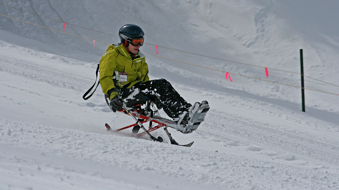 A kid going down a mountain on a ski sled