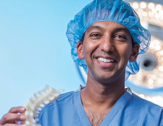 Dr. Sumeet Garg holds a 3d-printed spine.